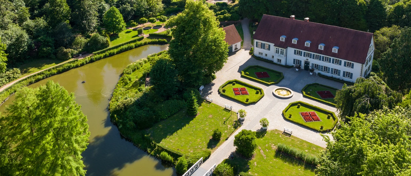 Preußisch Oldendorf-Kurensemble Bad Holzhausen-Teutoburger-Wald-Tourismus-D-Ketz-099 - Kopie-CC-BY-SA.jpg Luftaufnahme eines historischen Herrenhauses mit weitläufigem Garten und Wassergräben in Preußisch Oldendorf.