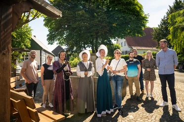 Stemwede-Stiftsort Levern-Teutoburger-Wald-Tourismus-D-Ketz-052.jpg Eine Gruppe lächelnder Menschen steht in historischem Kostüm und Freizeitkleidung im Freien.