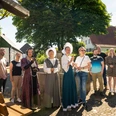 Stemwede-Stiftsort Levern-Teutoburger-Wald-Tourismus-D-Ketz-052.jpg Eine Gruppe lächelnder Menschen steht in historischem Kostüm und Freizeitkleidung im Freien.