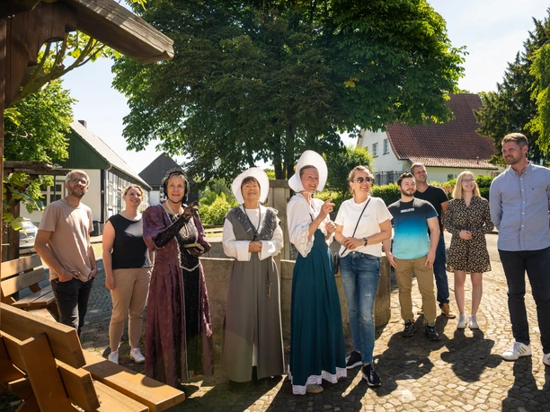 Stemwede-Stiftsort Levern-Teutoburger-Wald-Tourismus-D-Ketz-052.jpg Eine Gruppe lächelnder Menschen steht in historischem Kostüm und Freizeitkleidung im Freien.