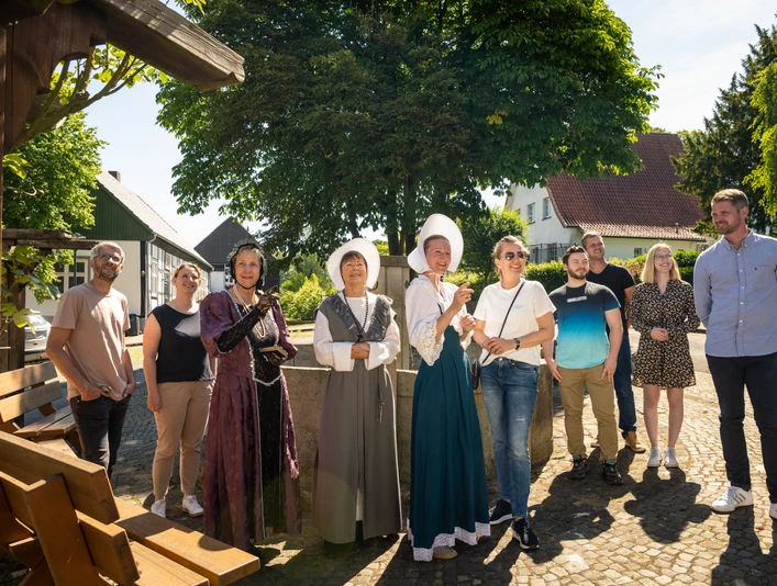 Stemwede-Stiftsort Levern-Teutoburger-Wald-Tourismus-D-Ketz-052.jpg Eine Gruppe lächelnder Menschen steht in historischem Kostüm und Freizeitkleidung im Freien.