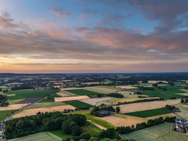 Stemberg-Stiftsort Levern-Teutoburger-Wald-Tourismus-D-Ketz-256.jpg Luftaufnahme einer weitläufigen, grünen Landschaft in der Umgebung von Stemwede bei Sonnenuntergang.