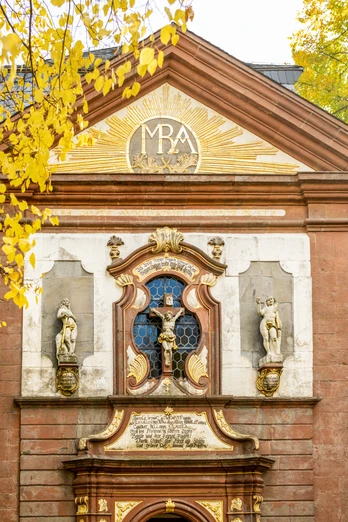 Lichtenau-Kirche Maria Heimsuchung-Teutoburger-Wald-Tourismus-D-Ketz-058-CC-BY-SA.jpg Barockkirche mit verzierten Fassaden, herbstlichen Bäumen und strahlender Sonne im Hintergrund.