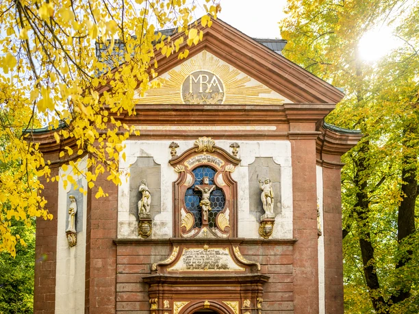 Lichtenau-Kirche Maria Heimsuchung-Teutoburger-Wald-Tourismus-D-Ketz-058-CC-BY-SA.jpg Barockkirche mit verzierten Fassaden, herbstlichen Bäumen und strahlender Sonne im Hintergrund.