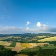 Lage-Hoerster Egge-Teutoburger-Wald-Tourismus-D-Ketz-009.jpg Panoramablick über eine ländliche Region mit Feldern, Wäldern und kleinen Dörfern unter blauem Himmel.