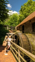 Bad-Oeynhausen-Wassermühle Bergkirchen Holzhausen-Teutoburger-Wald-Tourismus-D-Ketz-057.jpg Zwei Frauen stehen draußen vor dem Mühlrad der Wassermühle Bergkirchen in Bad Oeynhausen