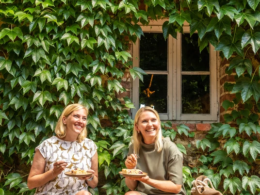 Bad-Oeynhausen-Wassermühle Bergkirchen Holzhausen-Teutoburger-Wald-Tourismus-D-Ketz-059.jpg Zwei Frauen sitzen auf einer Bank vor der Wassermühle Bergkirchen in Bad Oeynhausen