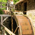 Bad-Oeynhausen-Wassermühle Bergkirchen Holzhausen-Teutoburger-Wald-Tourismus-D-Ketz-063.jpg Zwei Frauen stehen oberhalb des Mühlrads der Wassermühle Bergkirchen in Bad Oeynhausen und schauen auf das Mühlrad