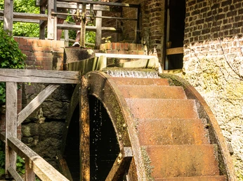 Bad-Oeynhausen-Wassermühle Bergkirchen Holzhausen-Teutoburger-Wald-Tourismus-D-Ketz-063.jpg Zwei Frauen stehen oberhalb des Mühlrads der Wassermühle Bergkirchen in Bad Oeynhausen und schauen auf das Mühlrad