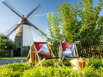 Minden-Windmühle Dützen-Teutoburger-Wald-Tourismus-D-Ketz-013.jpg Zwei Liegestühle auf grünem Gras vor einer historischen Windmühle mit blauen Himmel im Hintergrund.