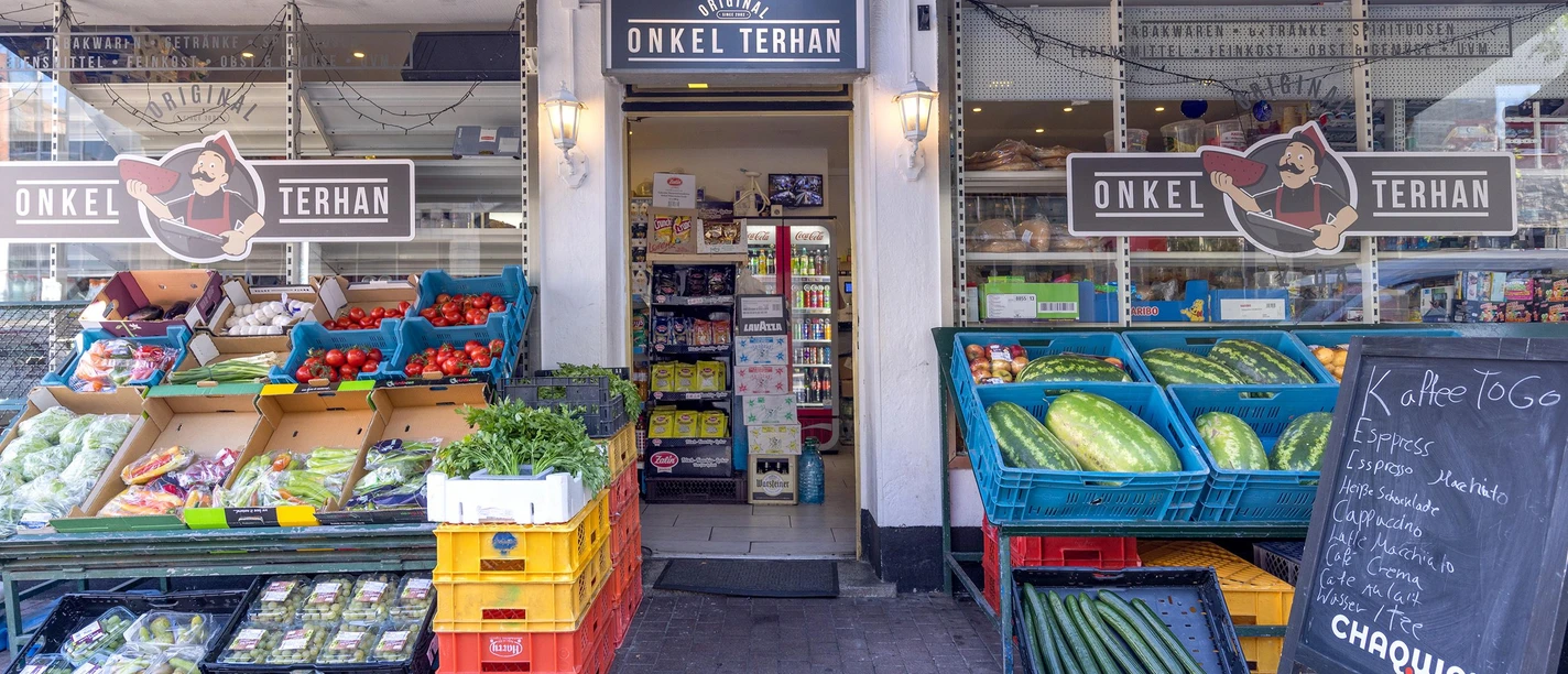 Eingang von Onkel Terhan mit Auslagen voller Obst, Gemüse und Melonen