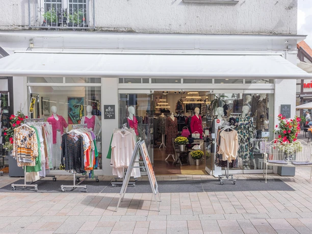 Modegeschäft Eliza mit Kleiderständern und Schaufensterpuppen vor der Glasfront
