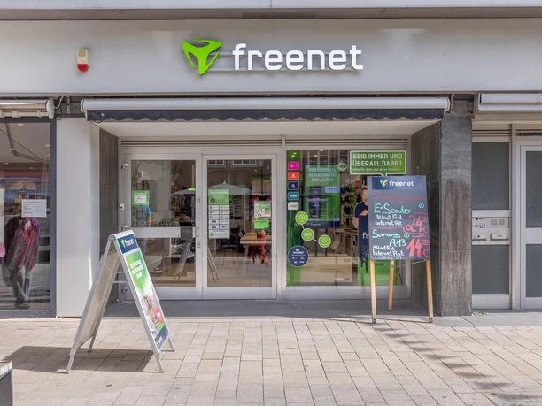 Eingang des freenet Shops mit Schaufenstern, Logo und Werbetafeln in der Fußgängerzone