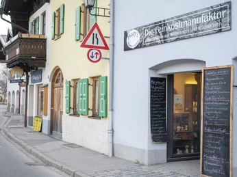 Marys Marmeladen Mary's Marmeladenladen mit grünen Fensterläden und handgeschriebenen Tafeln vor der Tür.