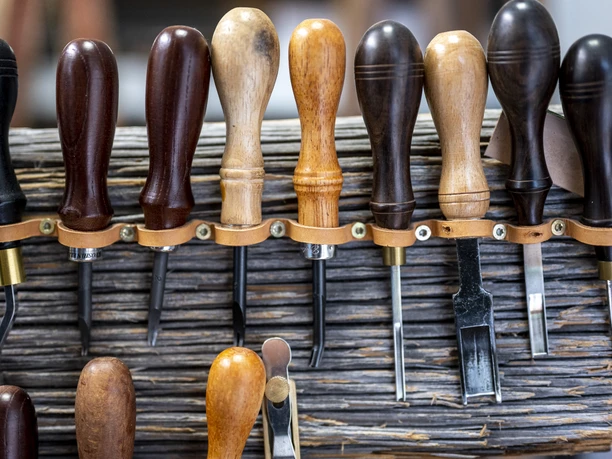 Handwerk & Design Bauer Eine Reihe von Werkzeuggriffen aus Holz, ordentlich in Halterungen angeordnet.