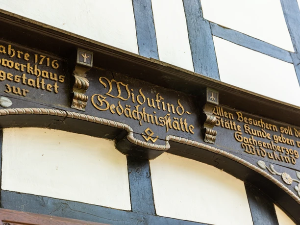 Enger-Widukind-Museum-Teutoburger-Wald-Tourismus-H-Tornow-006.JPG Detailaufnahme einer historischen Fachwerkfassade in Bad Gandersheim mit Inschrift "Widukind-Gedächtnisstätte".