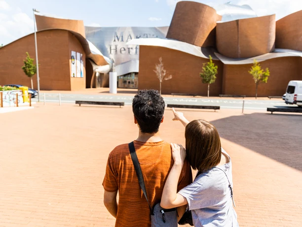 Ein Paar betrachtet das geschwungene, moderne Gebäude des Museo Guggenheim Bilbao in Spanien.