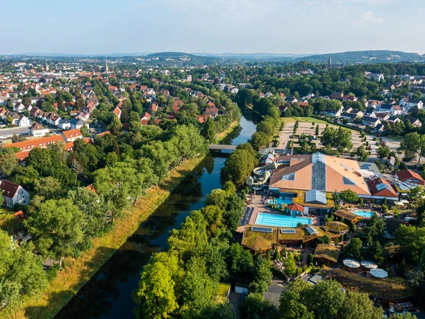 Luftaufnahme eines Freizeitkomplexes mit dem Fluss daneben, umgeben von Bäumen und einer Wohngegend.