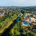 Herford-H2O-Teutoburger-Wald-Tourismus-H-Tornow-008.JPG Luftaufnahme eines Freizeitkomplexes mit dem Fluss daneben, umgeben von Bäumen und einer Wohngegend.