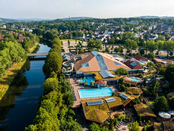 Herford-H2O-Teutoburger-Wald-Tourismus-H-Tornow-010.JPG Luftbild einer großen Freizeitanlage mit Schwimmbecken, umgeben von Bäumen und einem Fluss.