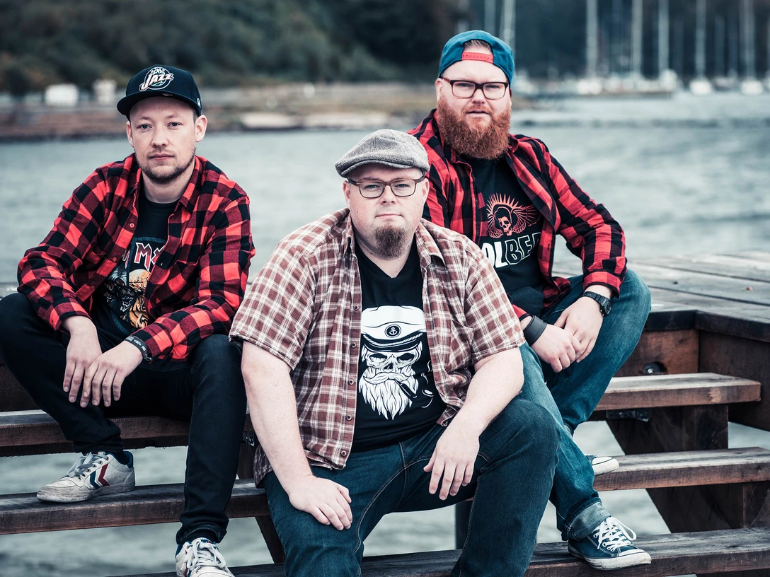 20171011_die_andersons(1).jpg Drei Männer sitzen auf einer Bank