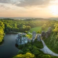 Luftaufnahme von den mystischen Externsteinen inmitten eines üppigen Waldes im Sonnenuntergang.