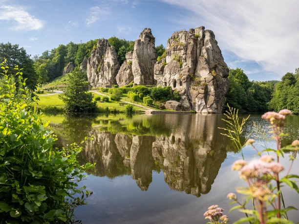 Horn-Bad Meinberg-Externsteine-Teutoburger-Wald-Tourismus-D-Ketz-057.jpg Felsformation Externsteine mit üppigem Grün und Teich, welche die Felsen spiegeln, an einem klaren Tag.