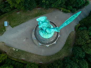 Hermannsdenkmal-Detmold-Teutoburger-Wald-Tourismus-D-Ketz-112.jpg Hermannsdenkmal aus der Vogelperspektive, umgeben von grünen Bäumen, mit mächtigem Schwert in der Hand.