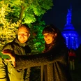 Detmold-Der Hermann leuchtet-Teutoburger-Wald-Tourismus-D-Ketz-105.jpg Zwei Personen machen ein Selfie vor dem abends angestrahlten Hermannsdenkmal in einem Park.