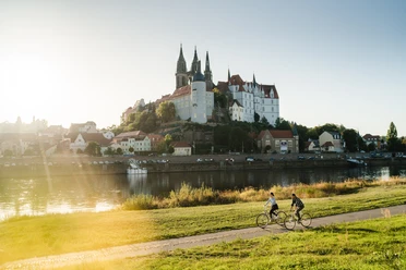 Fahrrad fahren in Meißen.jpg Fahrradfahrer auf dem Elberadweg, im Hintergrund die Albrechtsburg Meissen