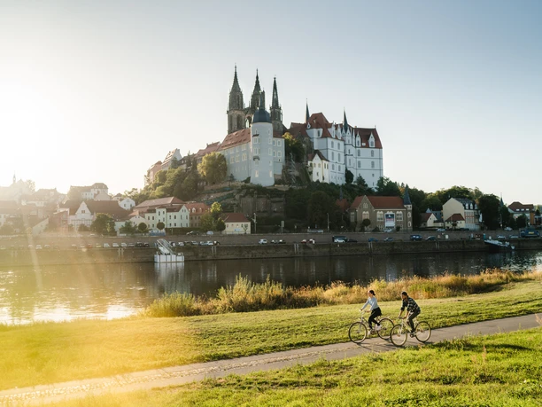 Fahrrad fahren in Meißen.jpg Fahrradfahrer auf dem Elberadweg, im Hintergrund die Albrechtsburg Meissen
