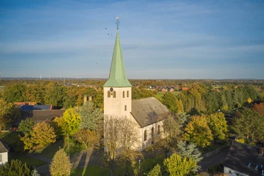 St.-Katharina-Kirche in Voltlage, Samtgemeinde Neuenkirchen Luchtfoto van de St. Catherine's Church, met zijn opvallende kerktoren, omringd door herfstkleurige bomen en het dorp.