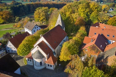 St.Urban Bissendorf Luftaufnahme der St.Urban Kirche in Bissendorf, umgeben von herbstlich gefärbten Bäumen und Gebäuden.