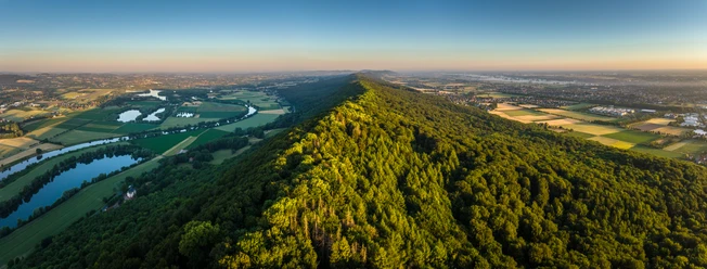 Porta Westfalica-Kaiser-Wilhelm-Denkmal-Teutoburger-Wald-Tourismus-D-Ketz-011.jpg Luftaufnahme eines üppig bewaldeten Hügels inmitten einer weiten, grünen Landschaft.