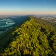 Porta Westfalica-Kaiser-Wilhelm-Denkmal-Teutoburger-Wald-Tourismus-D-Ketz-011.jpg Luftaufnahme eines üppig bewaldeten Hügels inmitten einer weiten, grünen Landschaft.