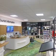 Tourist Information Paderborn Heller, moderner Raum der Tourist Information mit Info-Theke und Regalen voller Broschüren und Karten.