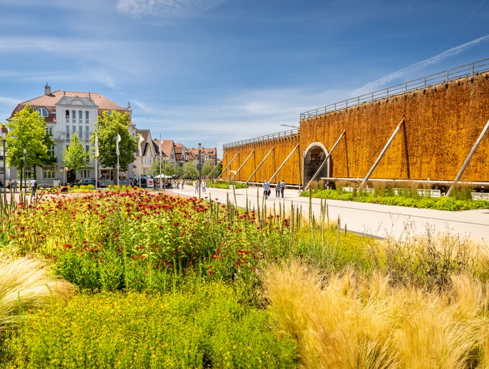 Bad Salzuflen-Gradierwerke-Teutoburger-Wald-Tourismus-D-Ketz-060-CC-BY-SA.jpg Gradierwerk mit Solewand in einer Parkanlage, umgeben von blühenden Pflanzen und einem klaren Himmel.
