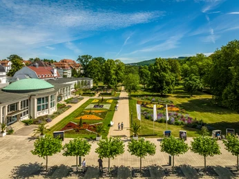 Bad Salzuflen-Kurpark-Teutoburger-Wald-Tourismus-D-Ketz-038-CC-BY-SA.jpg <p>Blick auf ein prunkvolles Kurhaus mit gepflegten Gärten, blühenden Beeten und sonnigem Himmel.</p>