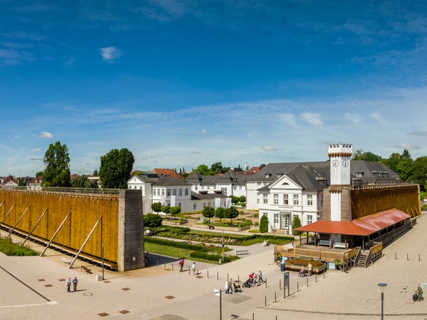 Gradierwerk im Kurpark: zwei lange Holzkonstruktionen mit salzhaltigem Wasser, umgeben von Gebäuden.