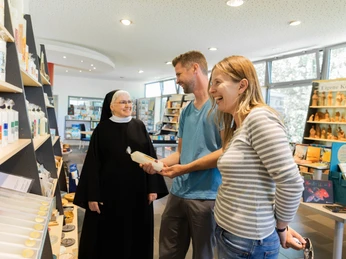 Beverungen-Abtei-Herstelle-Teutoburger-Wald-Tourismus-A-Röser-048.jpg <p>Eine Nonne führt ein Paar in einem Klosterladen, während sie gemeinsam lachen.</p><p>Een non begeleidt een stel in een kloosterwinkel terwijl ze samen lachen.</p> <p<p>A nun guides a couple in a monastery store while they laugh together.</p> <p