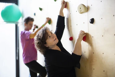Kletterwand MZG Bad Lippspringe Zwei Personen klettern an einer Indoor-Kletterwand, konzentriert und fokussiert in der Bewegung.