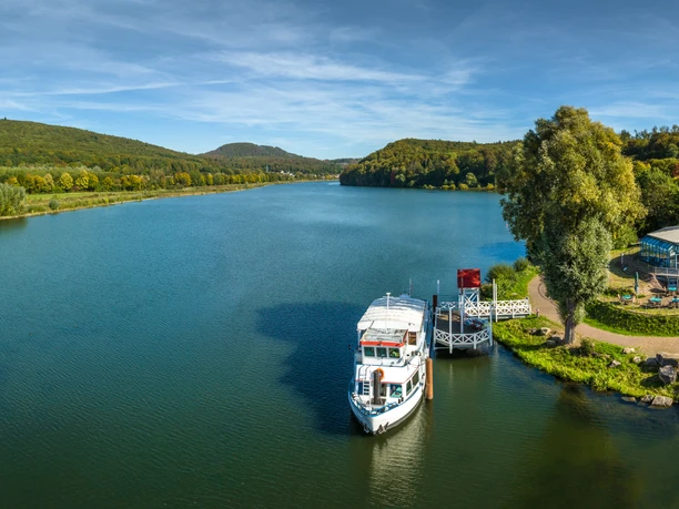 Schieder-Schwalenberg-Schiedersee-Teutoburger-Wald-Tourismus-D-Ketz-082.jpg Panorama der des Schiedersee mit Bootsanleger, umgeben von bewaldeten Hügeln und Grünflächen.