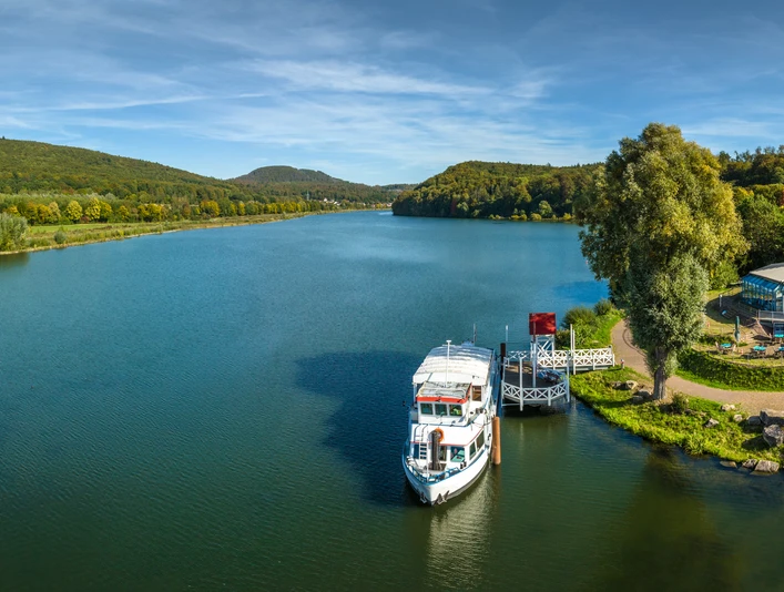 Schieder-Schwalenberg-Schiedersee-Teutoburger-Wald-Tourismus-D-Ketz-082.jpg Panorama der des Schiedersee mit Bootsanleger, umgeben von bewaldeten Hügeln und Grünflächen.