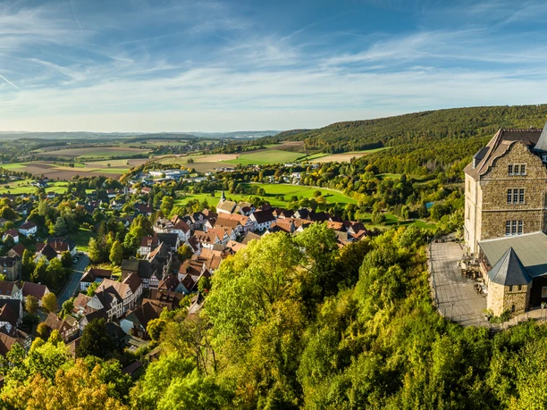 Schieder-Schwalenberg-Grafenblick-Teutoburger-Wald-Tourismus-D-Ketz-118-CC-BY-SA.jpg Luftaufnahme eines malerischen Dorfes in hügeliger Landschaft mit historischem Schloss am rechten Bildrand.