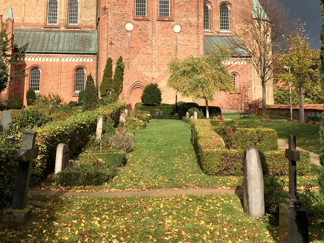 Dom_Friedhof_Roemer_032023.jpg Blick vom Friedhof auf den Dom mit rotem Backstein und hellgrünem Dach