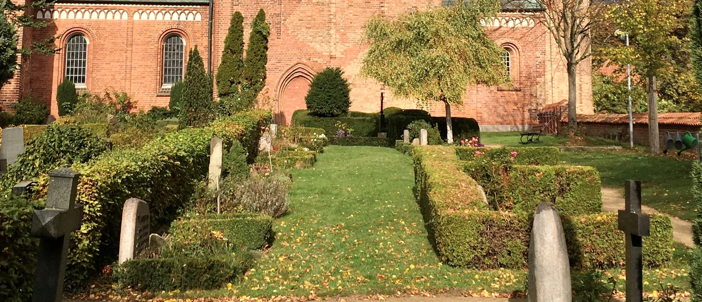 Dom_Friedhof_Roemer_032023.jpg Blick vom Friedhof auf den Dom mit rotem Backstein und hellgrünem Dach