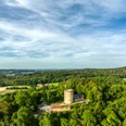 Luftaufnahme der mittelalterlichen Burg Ravensberg im Teutoburger Wald, umgeben von dichten Wäldern.