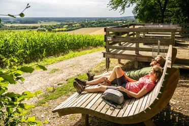 Borgholzhausen-Aussichtsplattform Berghauser Weg-Teutoburger-Wald-Tourismus-D-Ketz-071.jpg Holzplattform mit Entspannungsliegen und weitem Blick über grüne Felder und sanfte Hügel im Sommer.