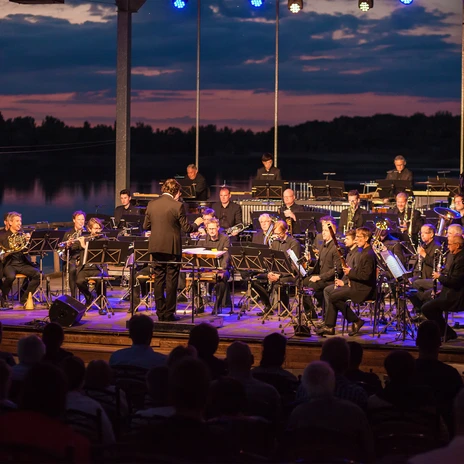 Koncert Saksońskiej Orkiestry Dętej na plaży Biedermeier wieczorem z jeziorem w tle