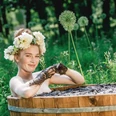 Moorbad Frau mit Blumenkranz im Haar genießt ein Moorbad in hölzerner Wanne, umgeben von Natur.